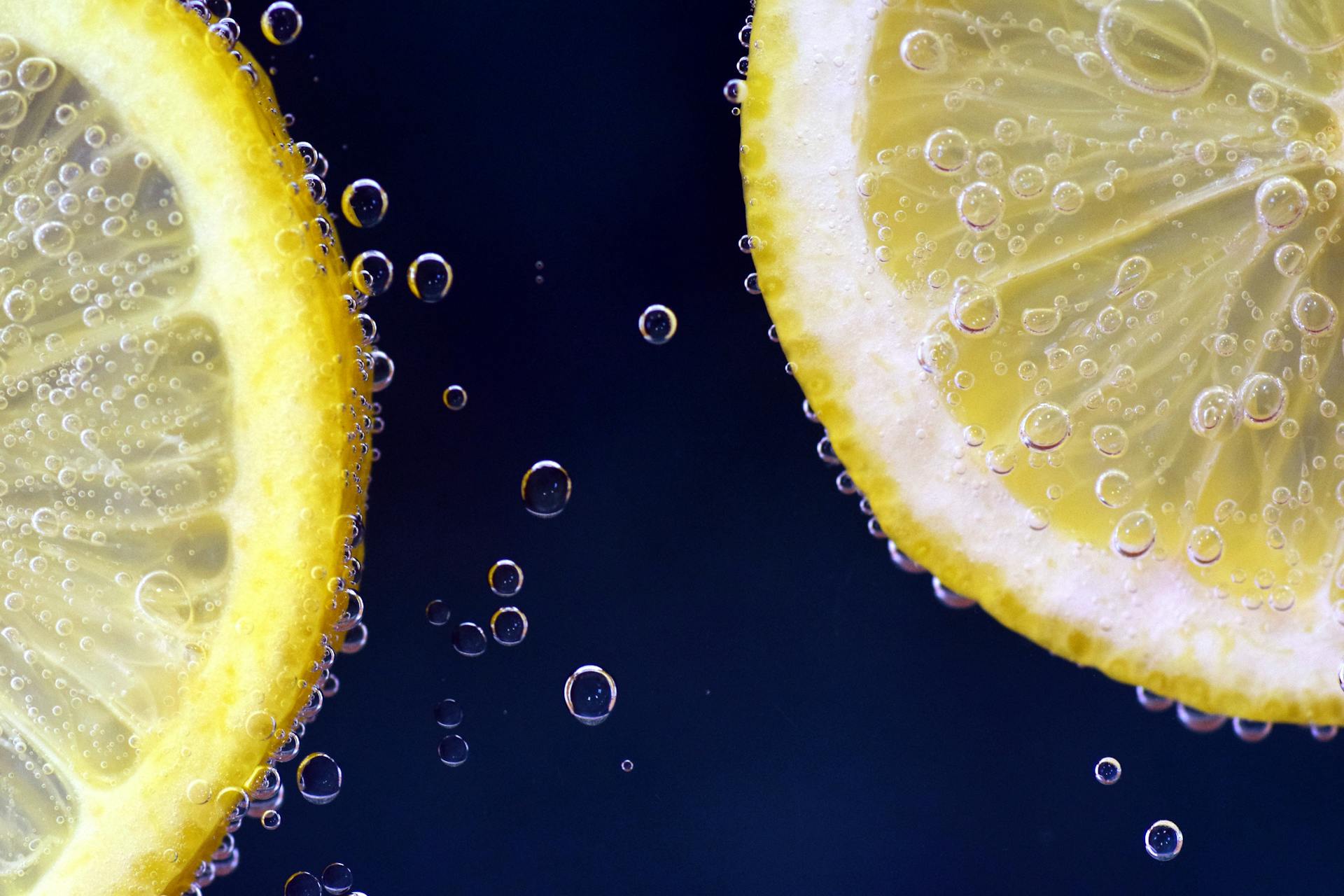 Close-up view of a lemon slice with bubbles in water